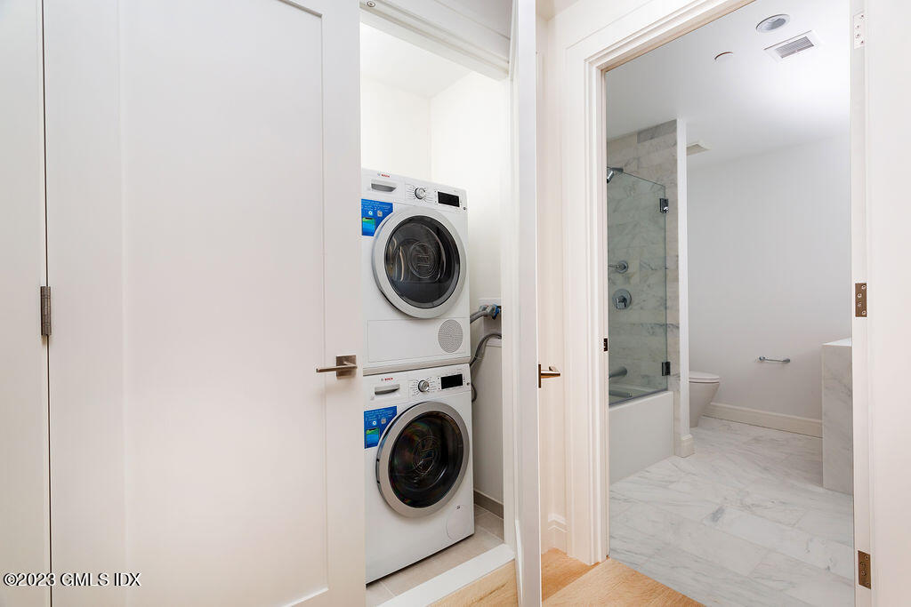 89 River Road, Unit 203 Cos Cob, CT 06807 - Photo 21 of 27 a view of a hallway with washer and dryer