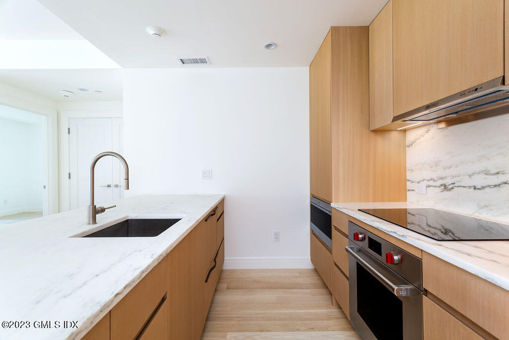 89 River Road, Unit 203 Cos Cob, CT 06807 - Photo 5 of 27 a kitchen with a sink and a refrigerator