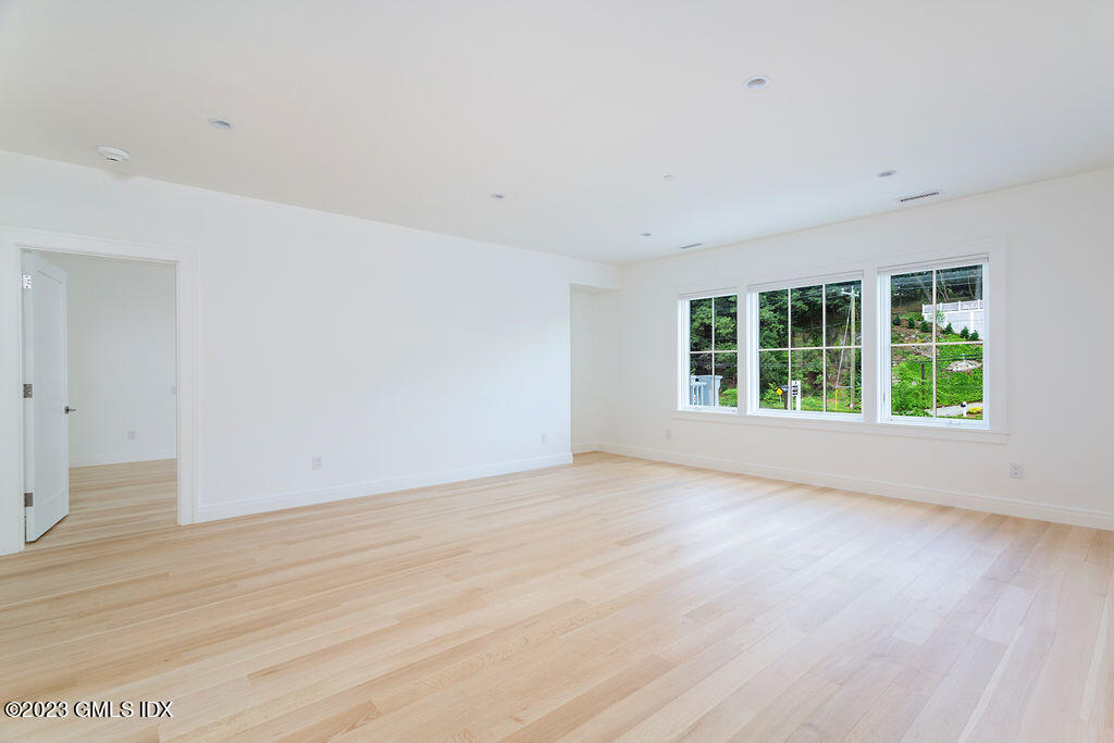 89 River Road, Unit 203 Cos Cob, CT 06807 - Photo 7 of 27 an empty room with wooden floor and windows
