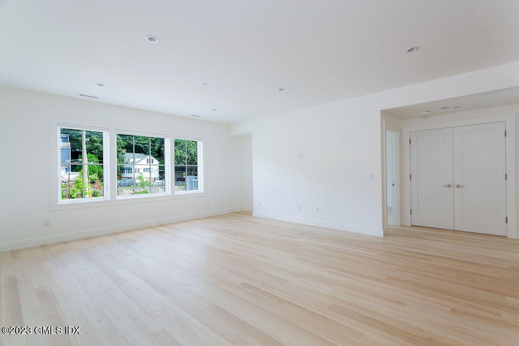 89 River Road, Unit 203 Cos Cob, CT 06807 - Photo 8 of 27 a view of an empty room with wooden floor and a window