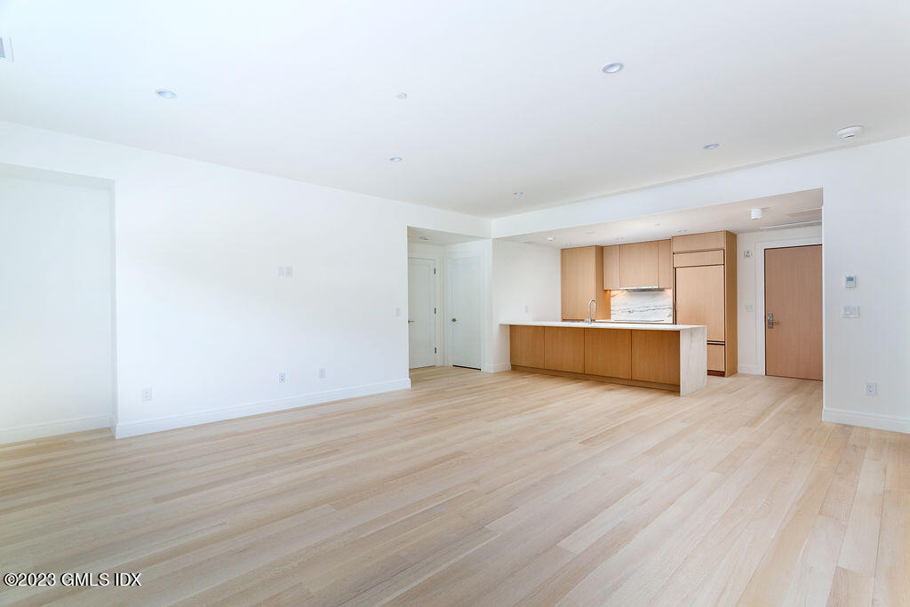 89 River Road, Unit 203 Cos Cob, CT 06807 - Photo 10 of 27 a view of an empty room with wooden floor and a cabinet