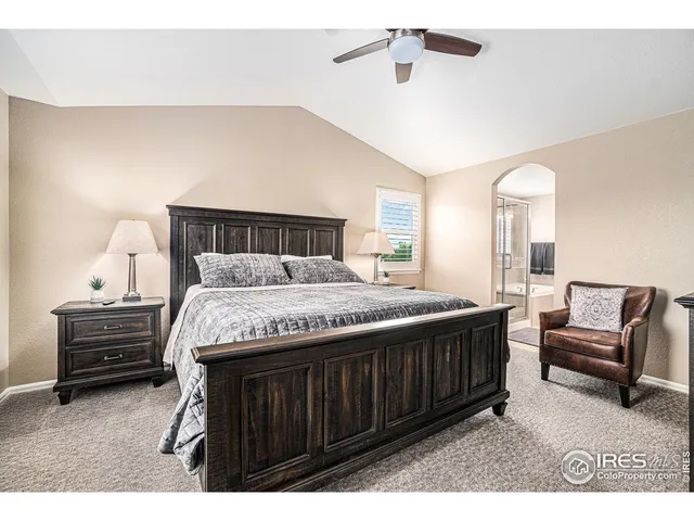 a spacious bedroom with a bed and a chandelier
