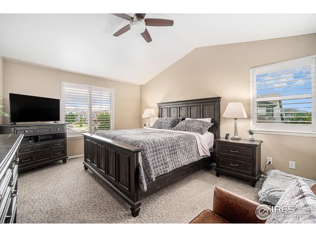 a bedroom with a bed and a flat tv screen on dresser