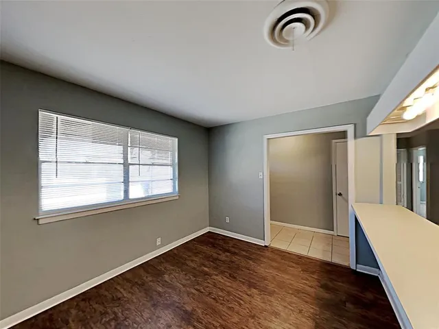 a view of a room with wooden floor and a window