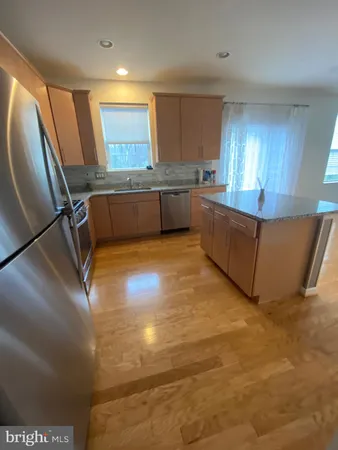 a kitchen with stainless steel appliances granite countertop a sink a stove top oven a counter space and cabinets