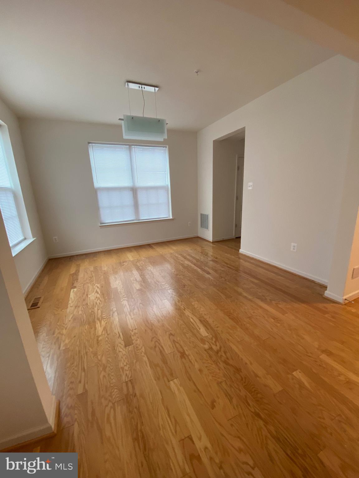 918 Ramble Run Road Baltimore, MD 21220 - Photo 4 of 23 an empty room with wooden floor and windows