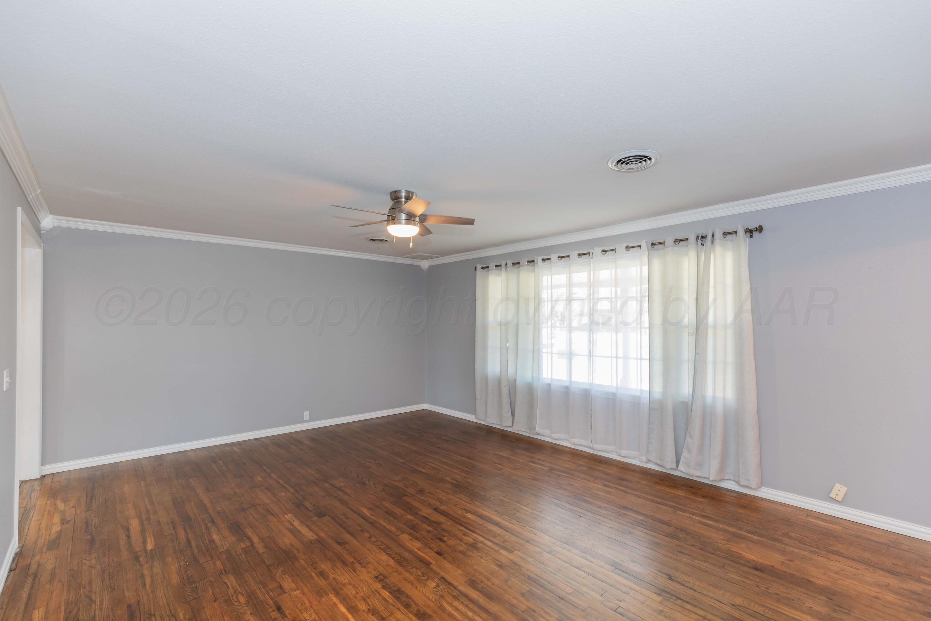 4309 Olsen Boulevard Amarillo, TX 79106 - Photo 12 of 45 a view of an empty room with wooden floor and a window