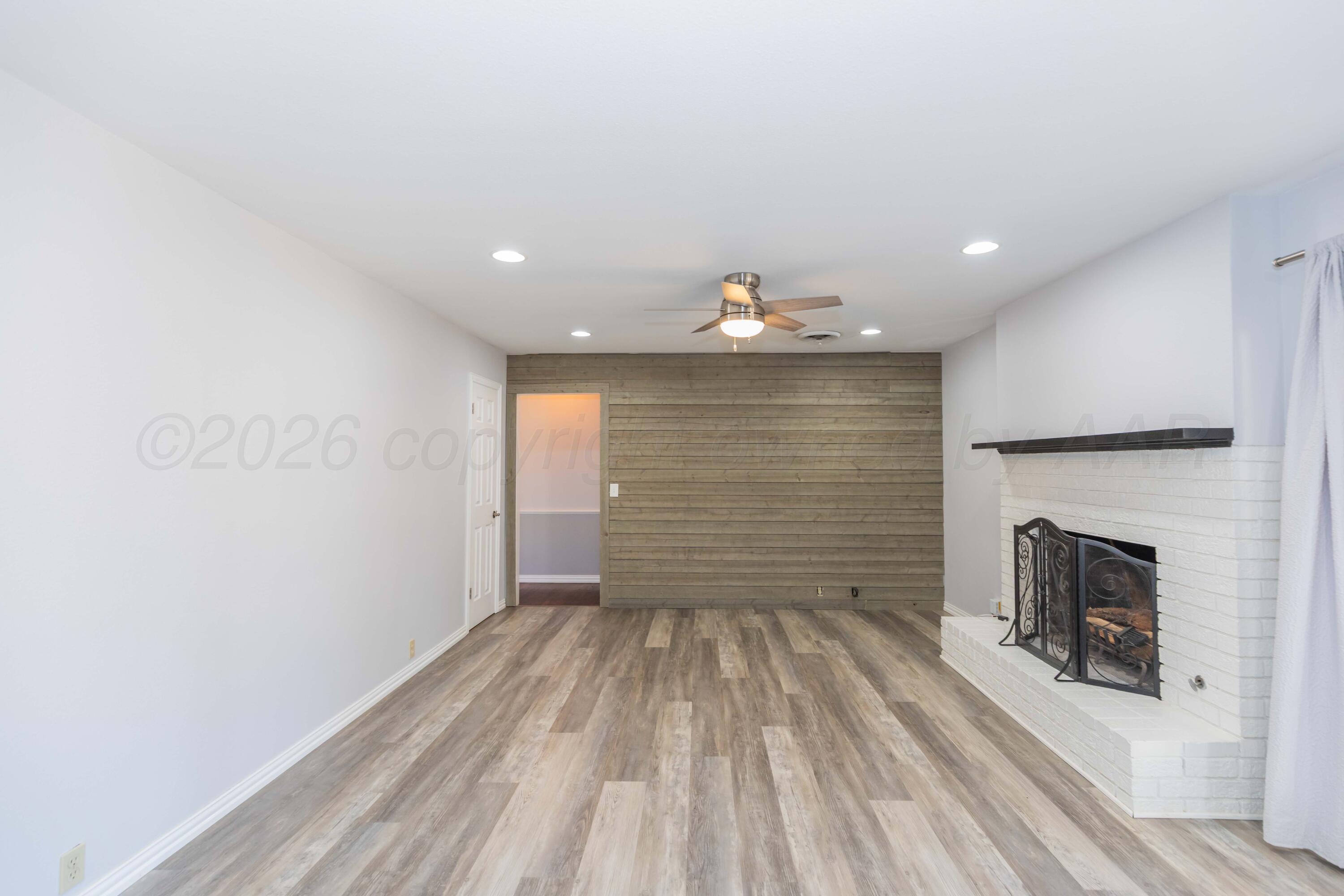 4309 Olsen Boulevard Amarillo, TX 79106 - Photo 19 of 45 a view of empty room with wooden floor and fireplace