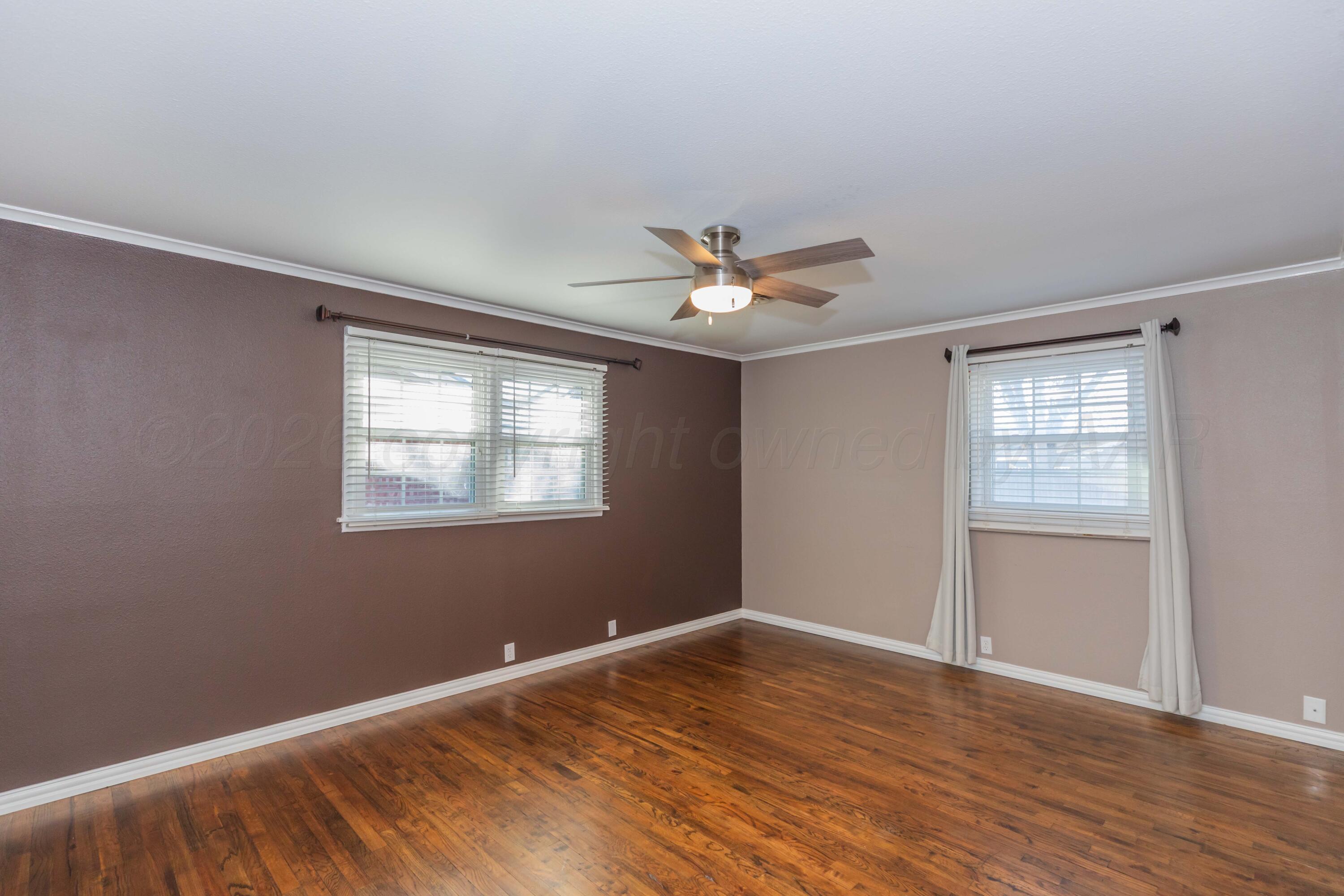 4309 Olsen Boulevard Amarillo, TX 79106 - Photo 20 of 45 a view of an empty room with wooden floor and a window