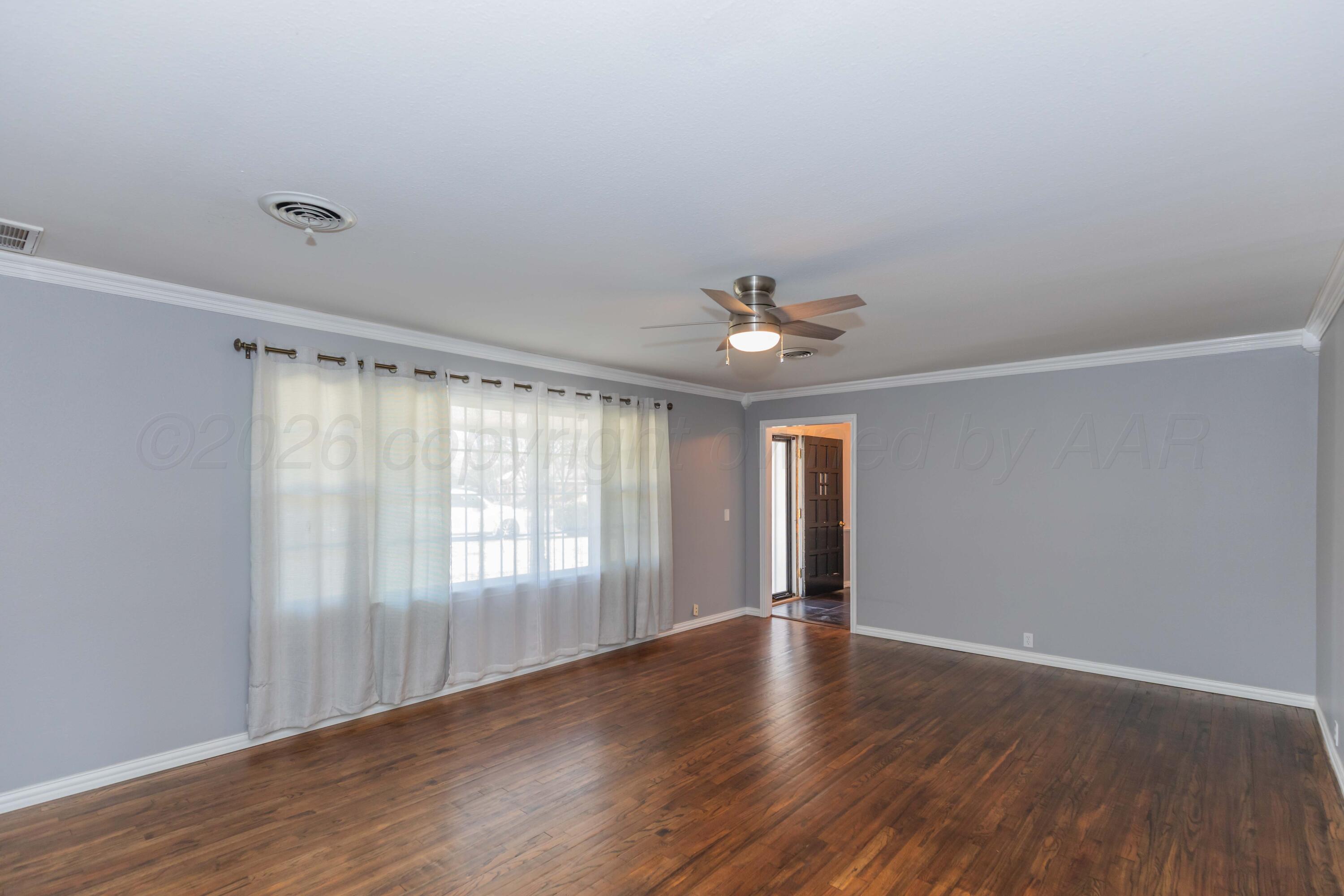 4309 Olsen Boulevard Amarillo, TX 79106 - Photo 2 of 45 a view of an empty room with wooden floor and a window