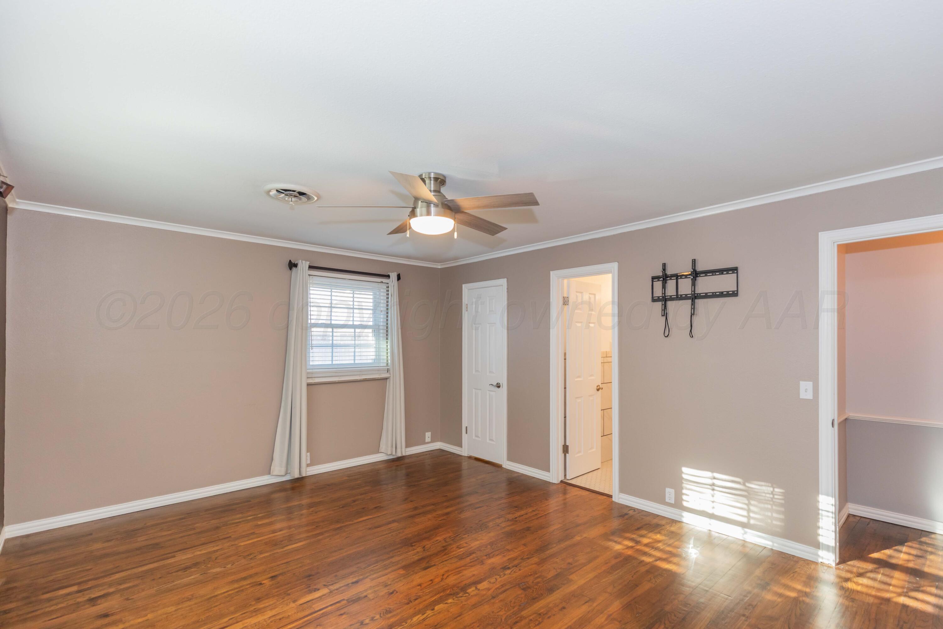 4309 Olsen Boulevard Amarillo, TX 79106 - Photo 21 of 45 a view of an empty room with wooden floor and a window