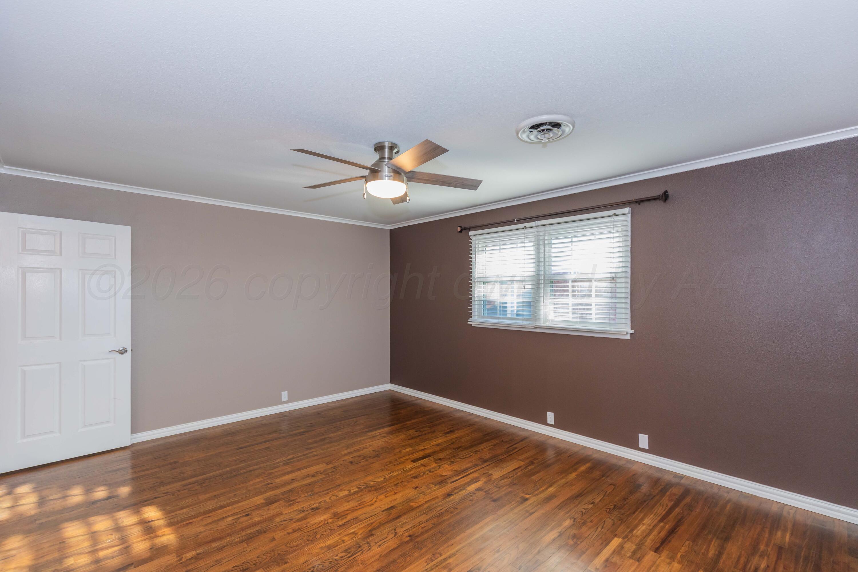 4309 Olsen Boulevard Amarillo, TX 79106 - Photo 23 of 45 a view of an empty room with wooden floor and a window
