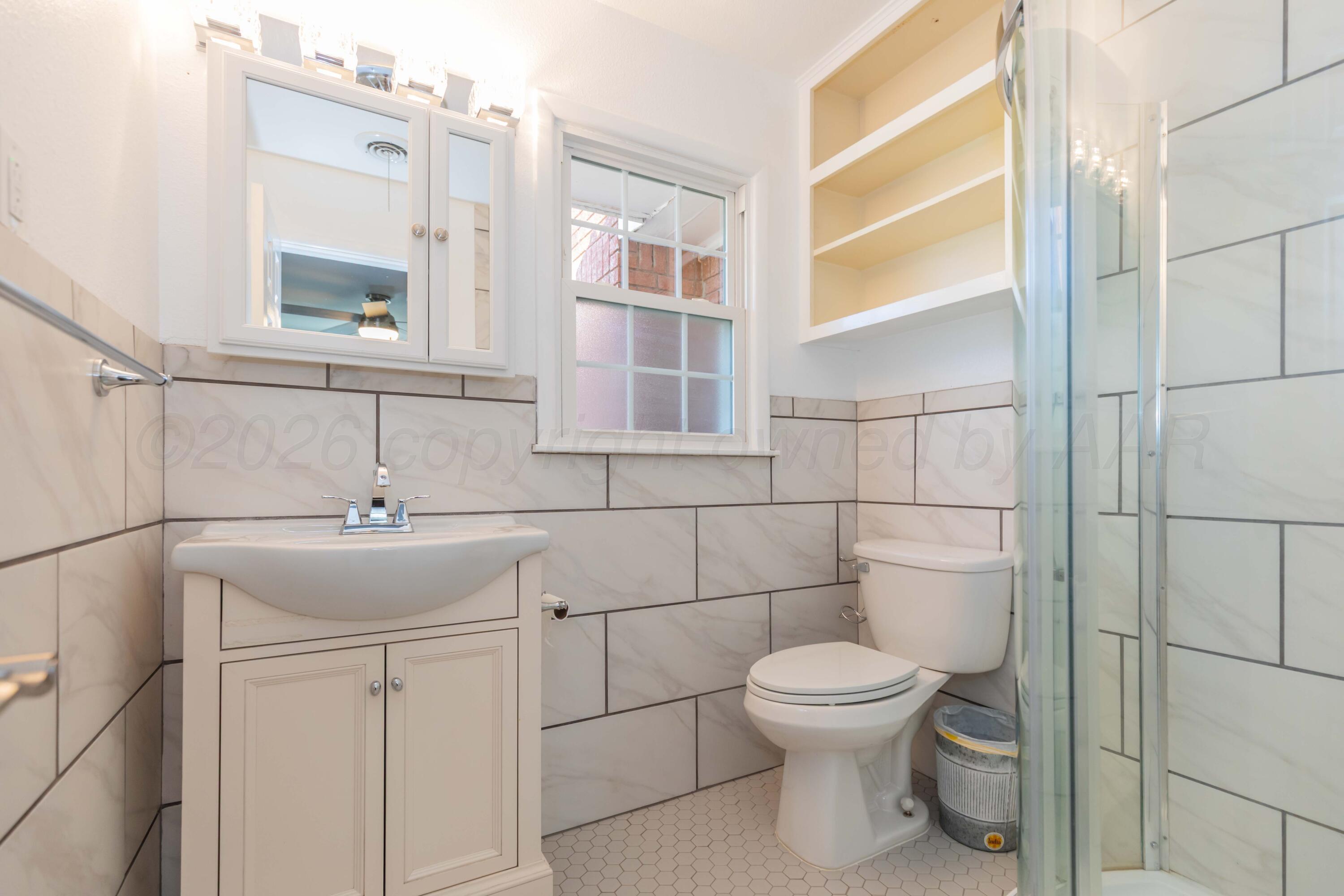 4309 Olsen Boulevard Amarillo, TX 79106 - Photo 24 of 45 a bathroom with a toilet sink and mirror