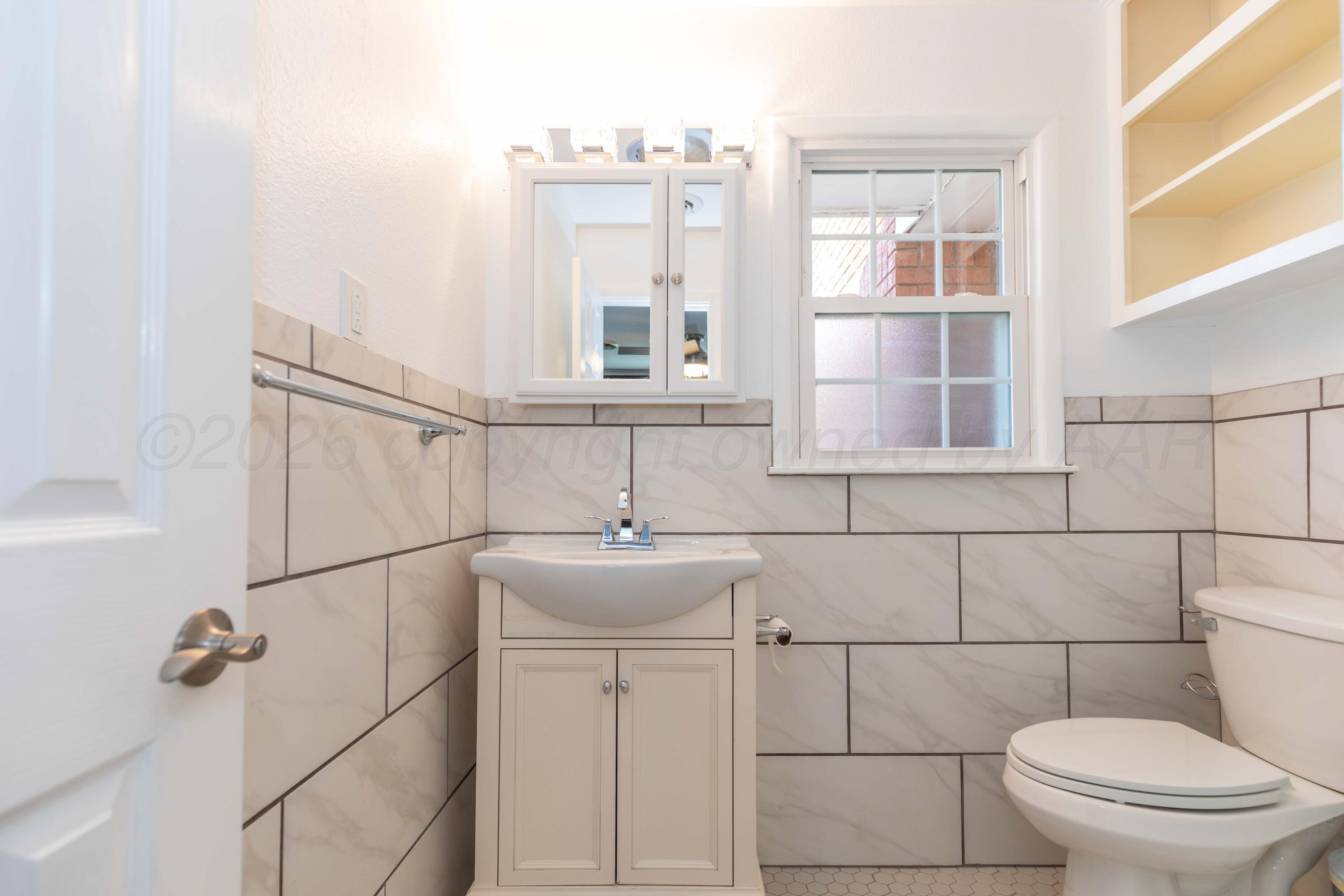 4309 Olsen Boulevard Amarillo, TX 79106 - Photo 25 of 45 a bathroom with a sink toilet and window