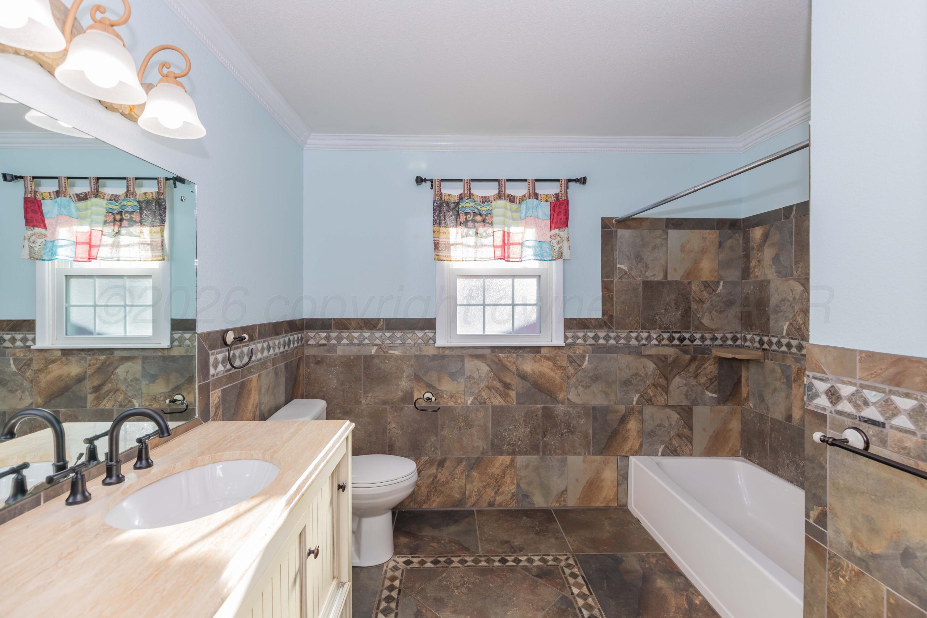4309 Olsen Boulevard Amarillo, TX 79106 - Photo 31 of 45 a bathroom with a sink a toilet and shower