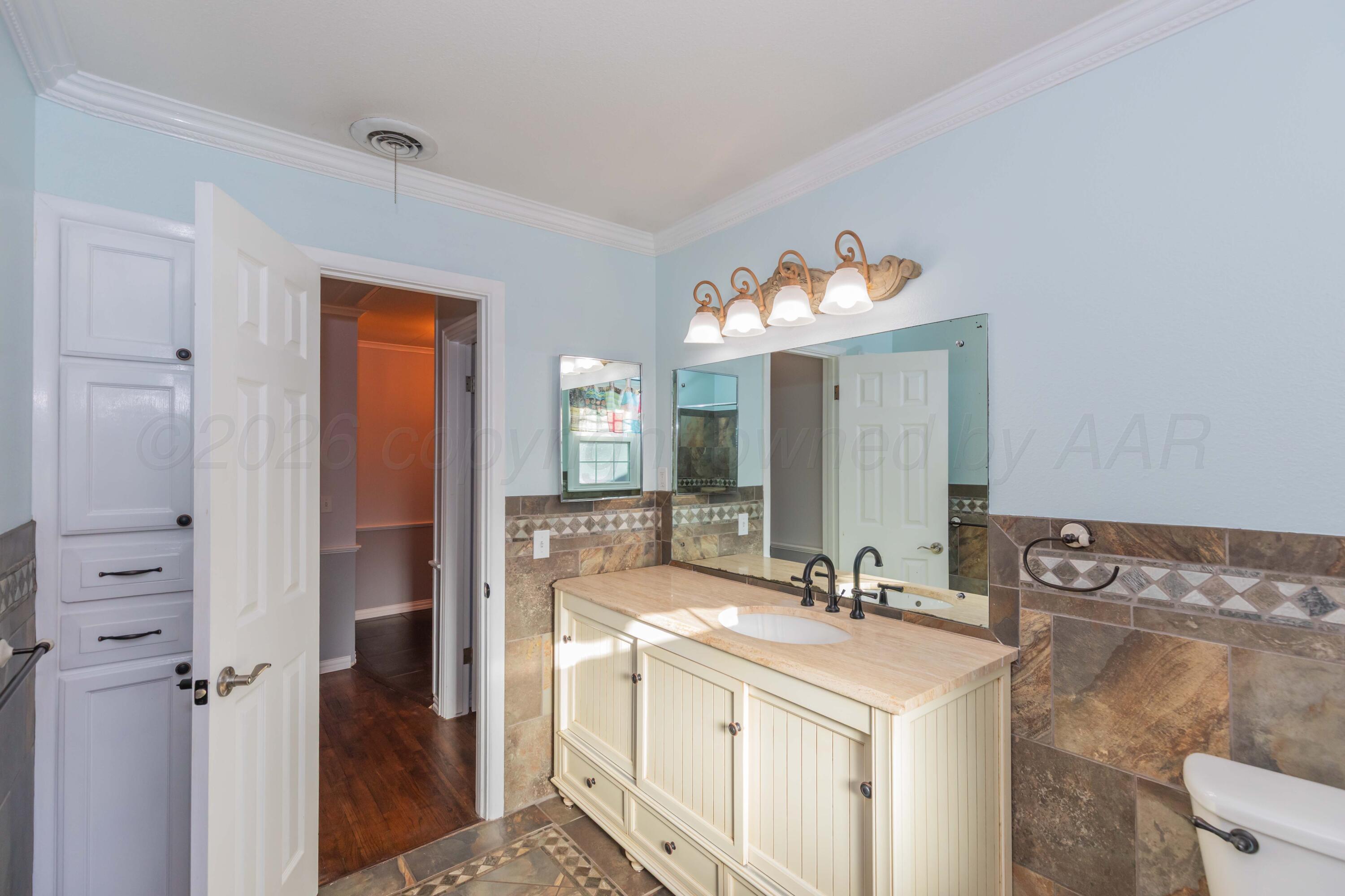 4309 Olsen Boulevard Amarillo, TX 79106 - Photo 32 of 45 a bathroom with a double vanity sink and a mirror