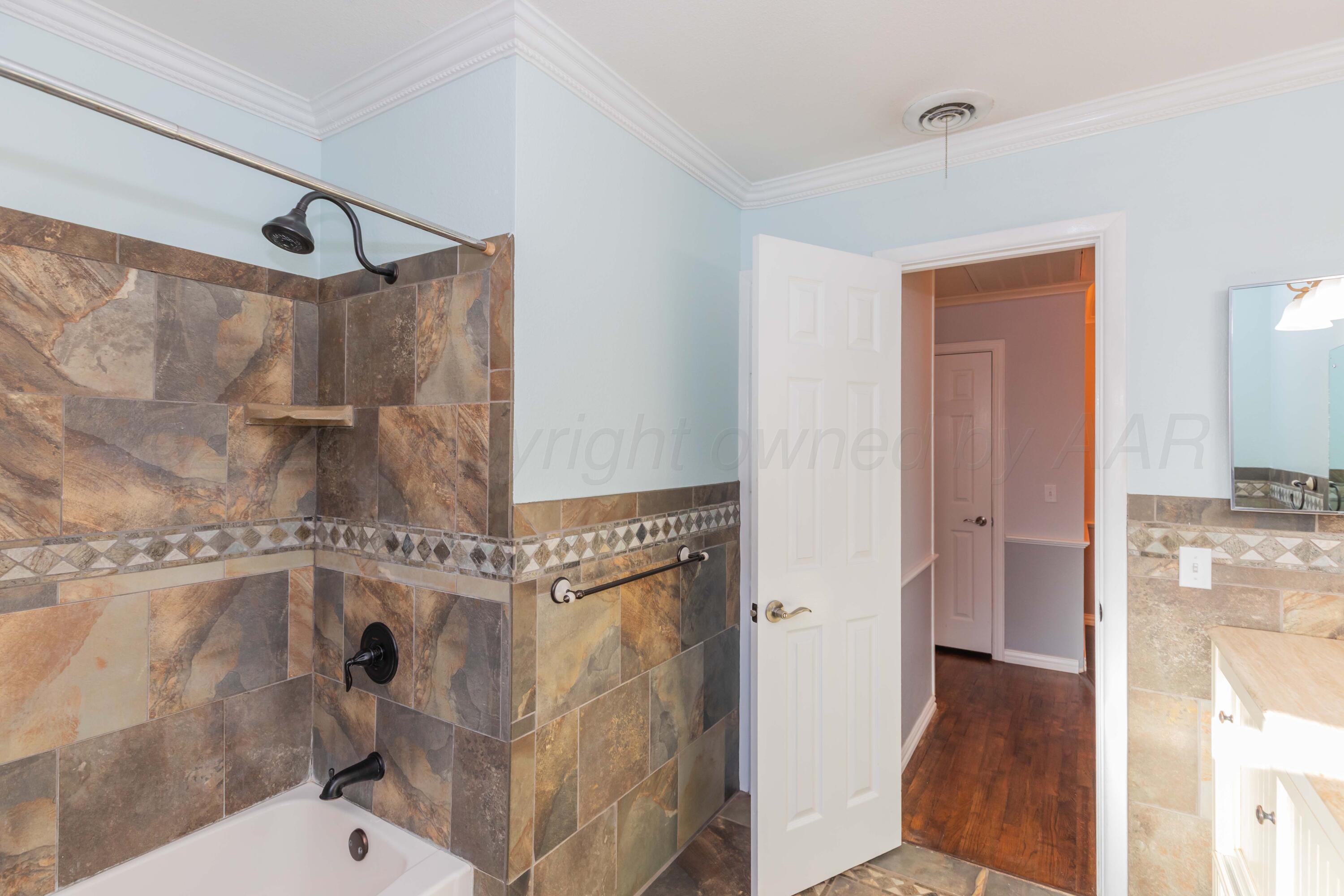 4309 Olsen Boulevard Amarillo, TX 79106 - Photo 33 of 45 a bathroom with a granite countertop shower mirror and a toilet
