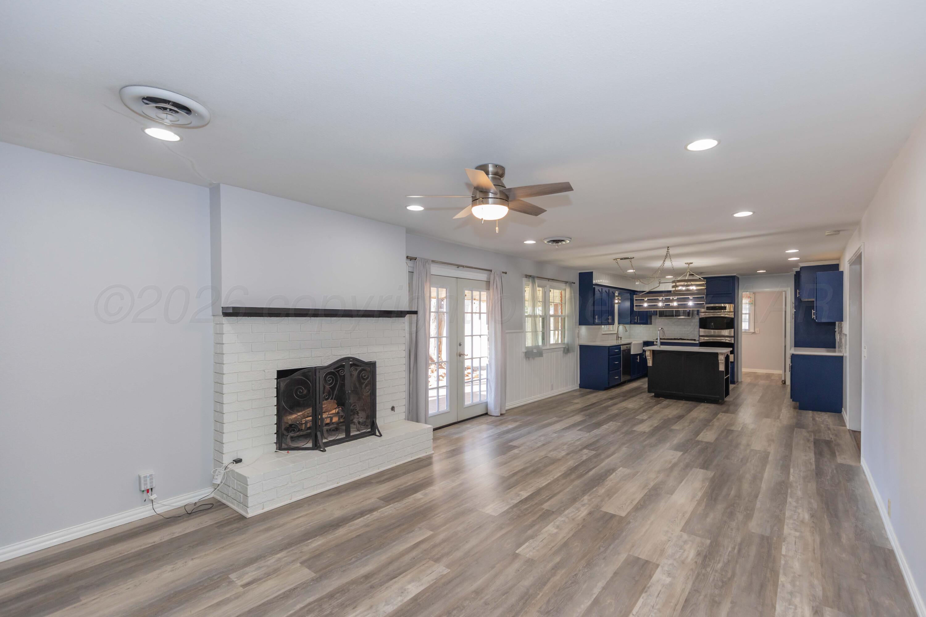 4309 Olsen Boulevard Amarillo, TX 79106 - Photo 6 of 45 an open kitchen with fireplace and wooden floor