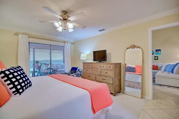 a bedroom with a bed a chandelier and a television