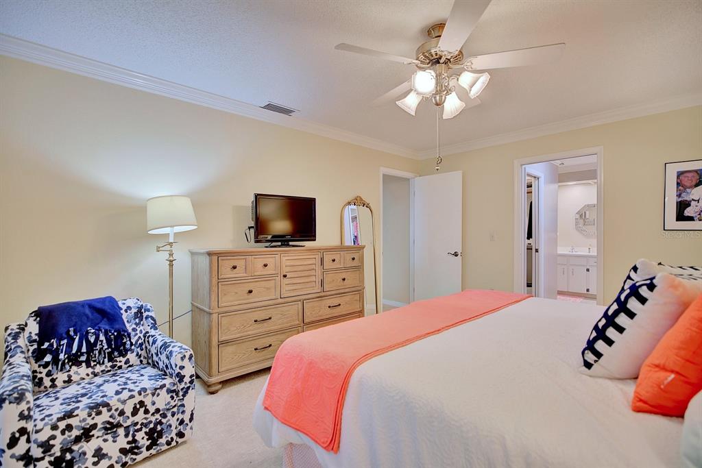 2025 Sylvester Road, Unit H2 Lakeland, FL 33803 - Photo 28 of 59 a bedroom with a bed a chandelier and a television