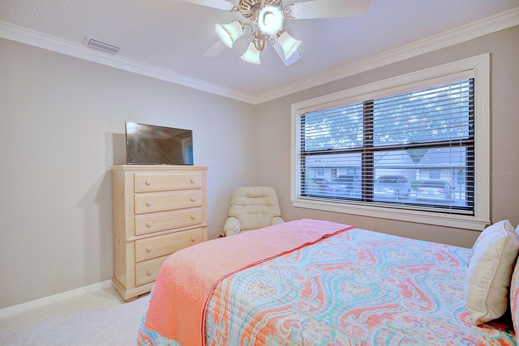 2025 Sylvester Road, Unit H2 Lakeland, FL 33803 - Photo 35 of 59 a bedroom with a bed and a flat tv screen on dresser