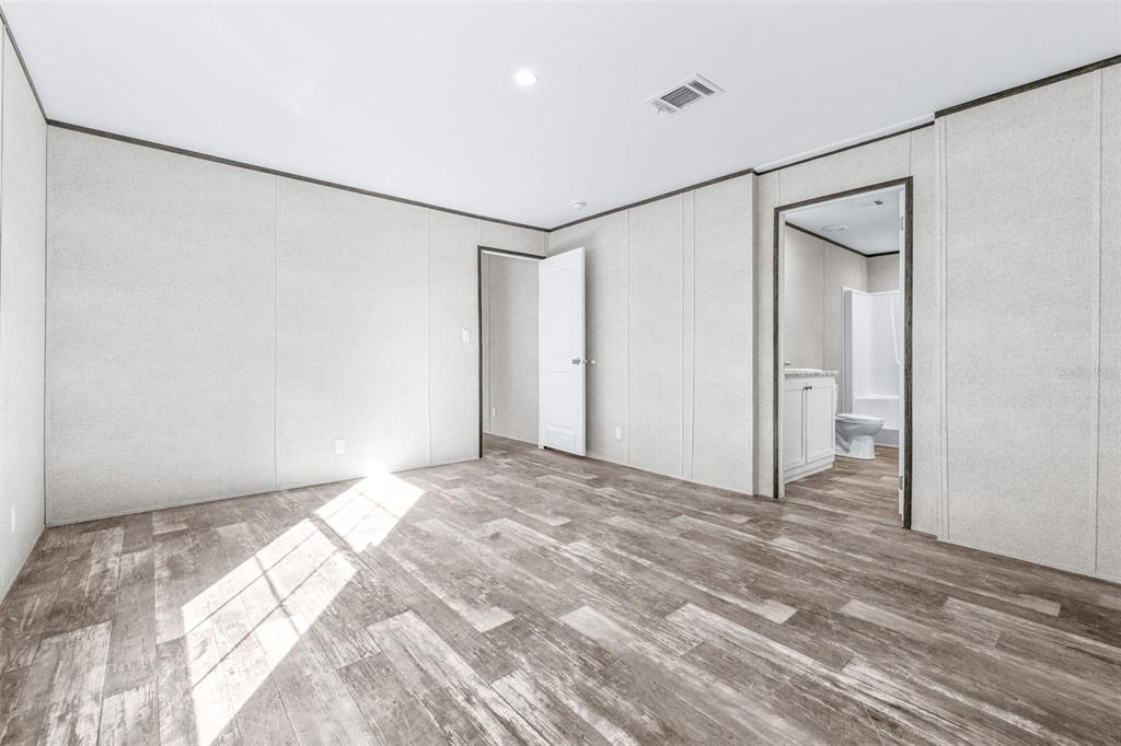 892 Southwest 124th Lane Webster, FL 33597 - Photo 11 of 29 a view of a room with wooden floor and a bathroom