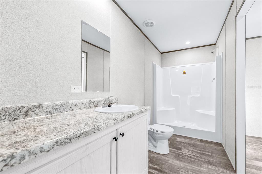 892 Southwest 124th Lane Webster, FL 33597 - Photo 13 of 29 a bathroom with a granite countertop sink a toilet and shower