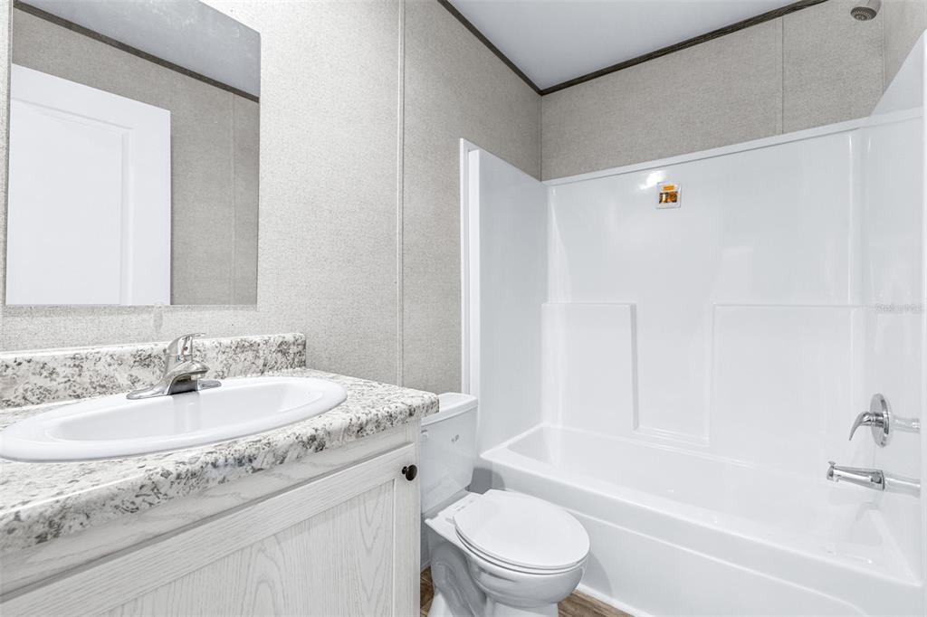 892 Southwest 124th Lane Webster, FL 33597 - Photo 15 of 29 a bathroom with a granite countertop sink a toilet and bathtub