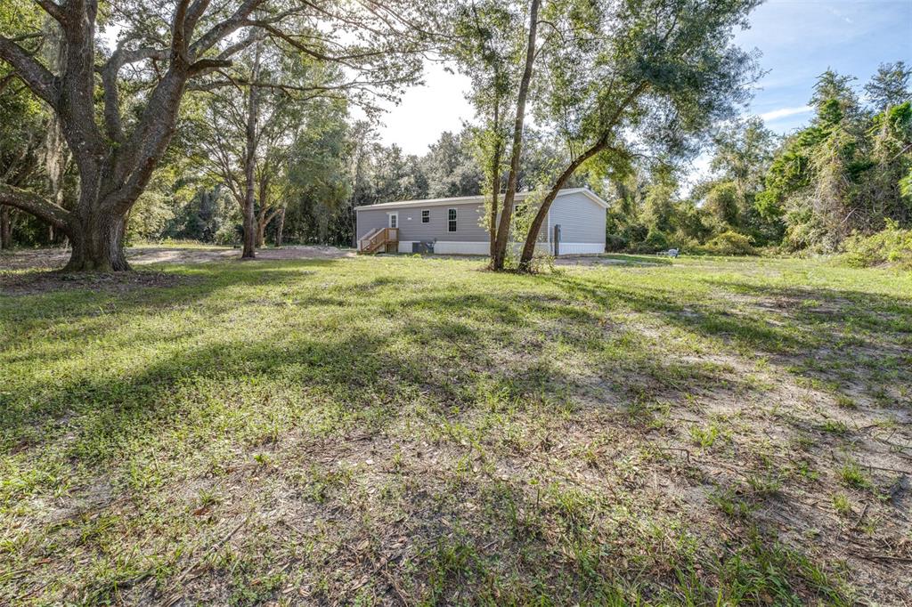 892 Southwest 124th Lane Webster, FL 33597 - Photo 19 of 29 a view of outdoor space with deck and trees