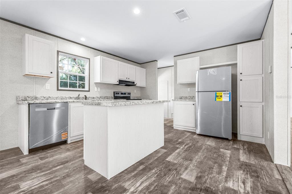 892 Southwest 124th Lane Webster, FL 33597 - Photo 8 of 29 a kitchen with refrigerator cabinets and wooden floor