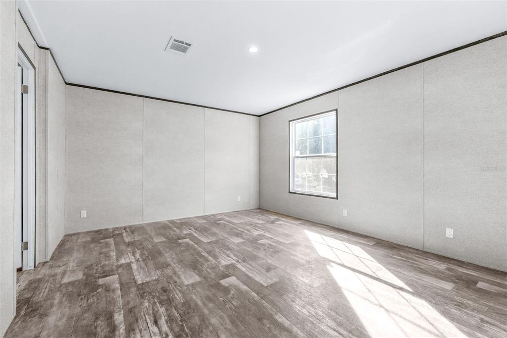 892 Southwest 124th Lane Webster, FL 33597 - Photo 10 of 29 a view of empty room with wooden floor and fan