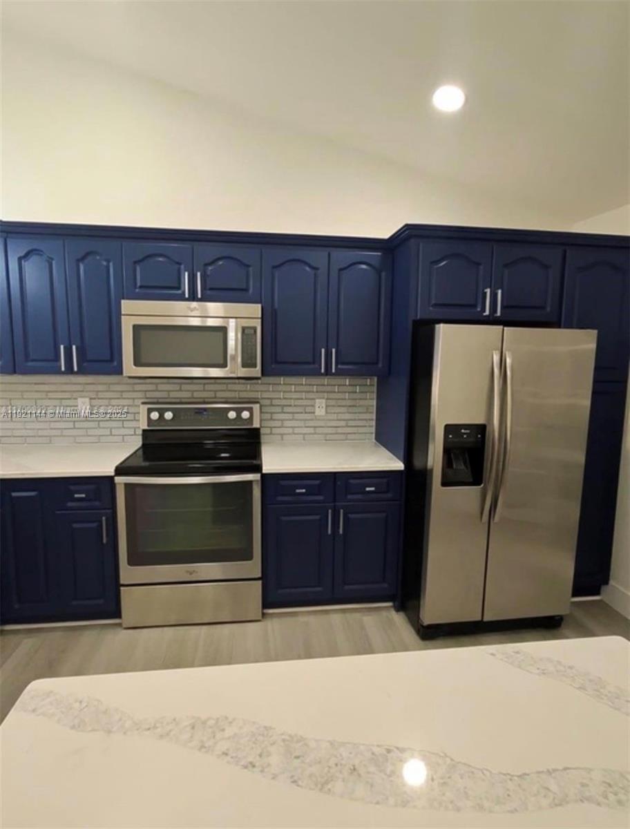 1430 Southwest 85th Terrace Pembroke Pines, FL 33025 - Photo 12 of 27 a kitchen with a refrigerator and a stove top oven