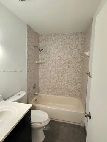 a bathroom with a granite countertop toilet a sink and bathtub