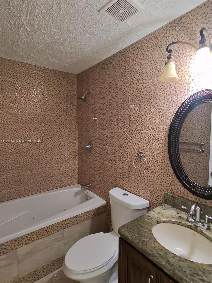 1430 Southwest 85th Terrace Pembroke Pines, FL 33025 - Photo 20 of 27 a bathroom with a granite countertop toilet a sink and bathtub
