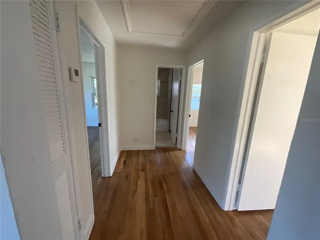 a view of a hallway with wooden floor and staircase