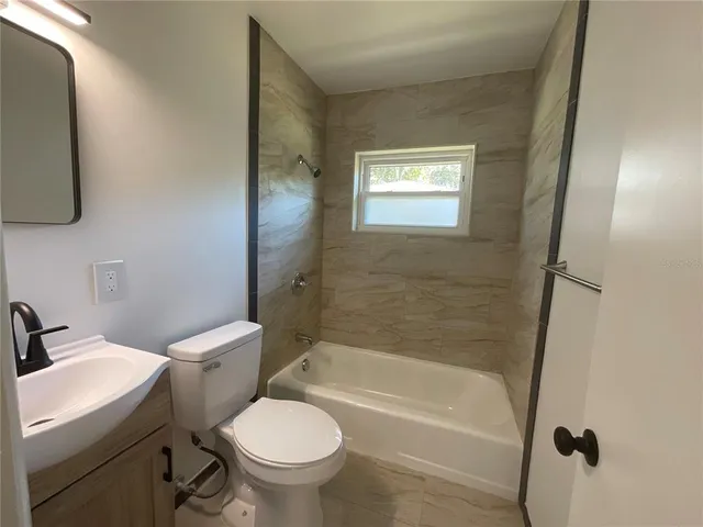 a bathroom with a toilet a sink and bathtub