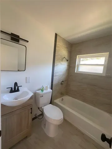 a bathroom with a toilet a sink and bathtub