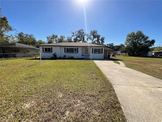 a view of a house with pool and a yard