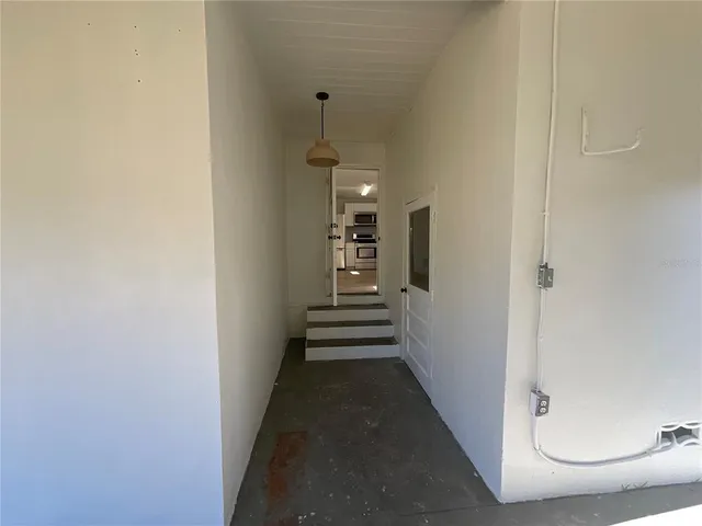a view of a hallway with wooden floor and stairs