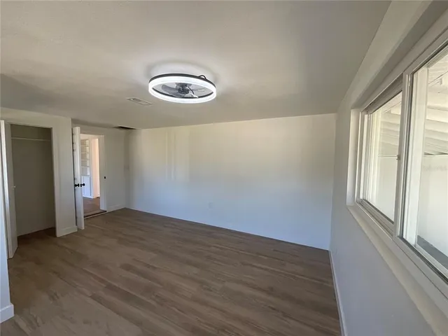 a view of a room with wooden floor and windows