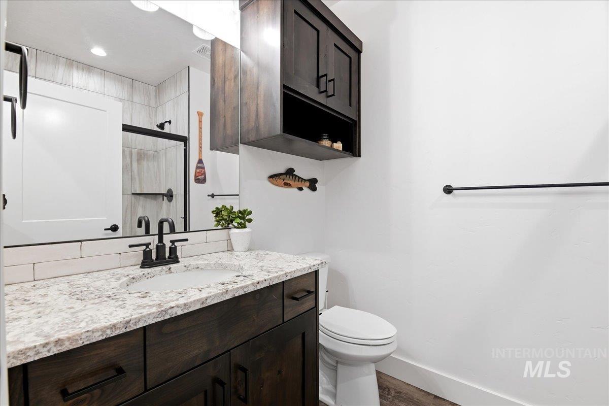 13152 Hawks Bay Road Donnelly, ID 83615 - Photo 21 of 29 Bathroom featuring a dark wood-finish vanity with a light speckled countertop and undermount sink
