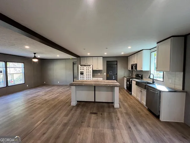a large kitchen with a lot of counter space and a wooden floor
