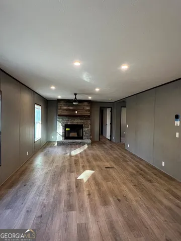 a view of empty room with wooden floor and furniture