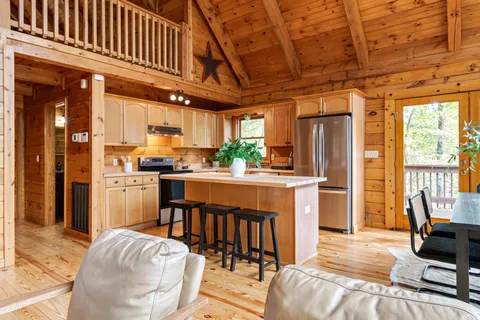 a kitchen with stainless steel appliances granite countertop a sink a stove a refrigerator cabinets and a refrigerator