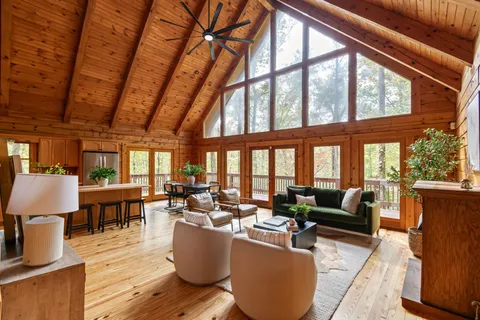 a living room with fireplace furniture and a large window