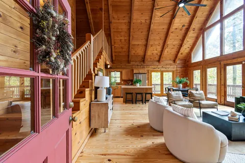 a living room with furniture a fireplace and a floor to ceiling window