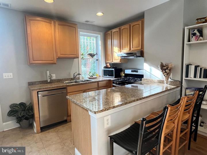 1610 4th Street Northwest Washington, DC 20001 - Photo 4 of 21 a kitchen with a stove a sink and a microwave