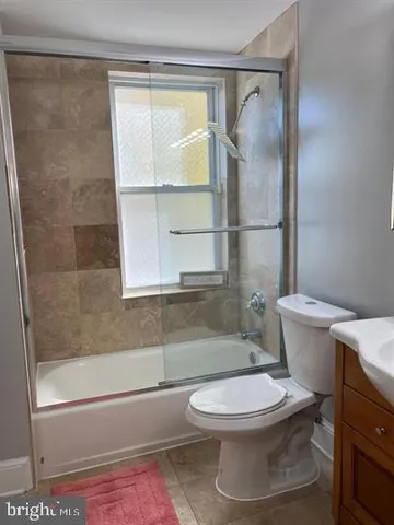 a white toilet sitting next to a bath tub and a shower