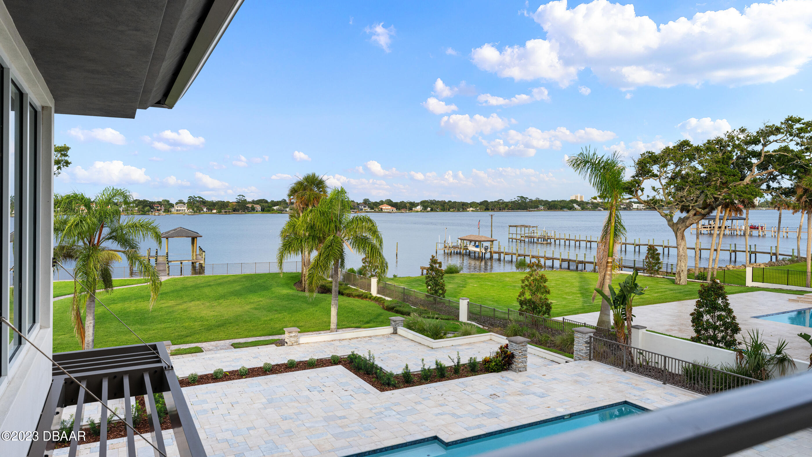 437 North Beach Street Ormond Beach, FL 32174 - Photo 55 of 162 a view of a patio with table and chairs potted plants with wooden floor and lake view