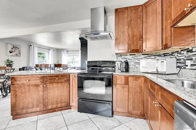 a kitchen with stainless steel appliances granite countertop a stove sink and cabinets